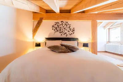 two beds in a room with wooden ceilings at Un Sogno Tra Le Dolomiti in Frena