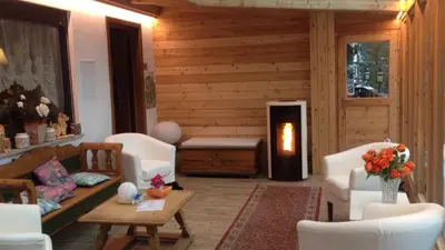 a living room with white furniture and a fireplace at Albergo Garni Edy (B&B) in Canazei