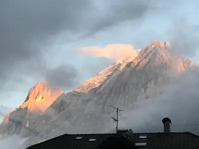 a mountain obscured by clouds in front of a building at Albergo Garni Edy (B&B) in Canazei