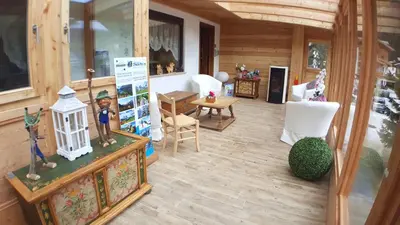 a room with a porch with chairs and a table at Albergo Garni Edy (B&B) in Canazei