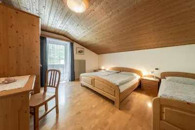 a bedroom with two beds and a wooden ceiling at Ciasa Miriam in La Valle