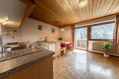 a kitchen with a sink and a large window at Ciasa Miriam in La Valle