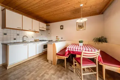 a kitchen with a table and chairs in a room at Ciasa Miriam in La Valle