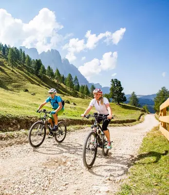 two people riding bikes on a dirt road at Peterwieshof in Funes