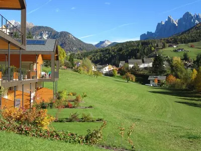 a house on a hill with mountains in the background at Peterwieshof in Funes