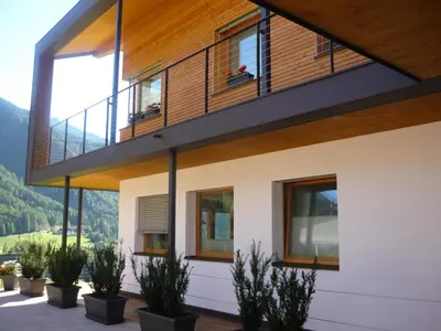 a house with a balcony with plants at Peterwieshof in Funes