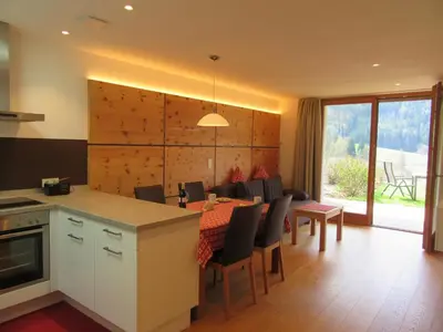 a kitchen and dining room with a table and chairs at Peterwieshof in Funes