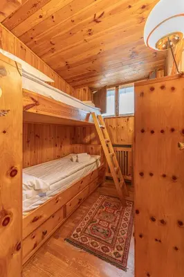 a bedroom with bunk beds in a wooden cabin at Casa Fior di Ghiaccio in Cortina dʼAmpezzo