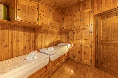 a room with two beds in a wooden cabin at Casa Fior di Ghiaccio in Cortina dʼAmpezzo