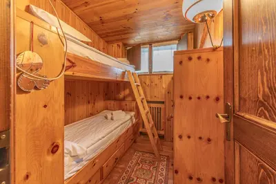 a bedroom with two bunk beds in a wooden cabin at Casa Fior di Ghiaccio in Cortina dʼAmpezzo