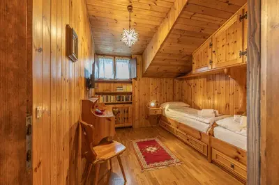 a bedroom with a bed in a wooden cabin at Casa Fior di Ghiaccio in Cortina dʼAmpezzo