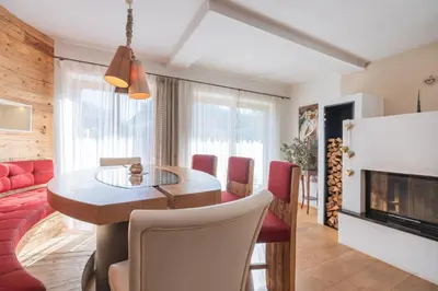 a living room with a dining table and a fireplace at Sweethome Apple in Fiumes