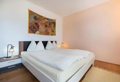 a bedroom with a white bed and a painting on the wall at Sweethome Apple in Fiumes