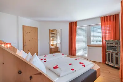 a bedroom with a large bed with red roses on it at Sweethome Apple in Fiumes
