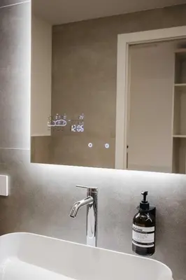 a bathroom sink with a mirror and a bottle of soap at ecHo Apartments & SPA in Bressanone
