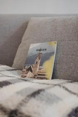 a book sitting on top of a bed at ecHo Apartments & SPA in Bressanone