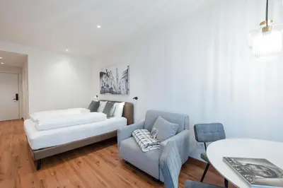 a living room with a couch and a chair at ecHo Apartments & SPA in Bressanone