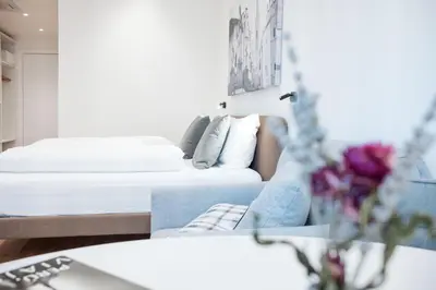 a living room with two beds and a vase of flowers at ecHo Apartments & SPA in Bressanone