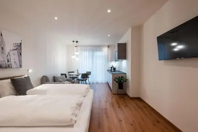 a hotel room with two beds and a dining room at ecHo Apartments & SPA in Bressanone