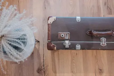 an old suitcase on the floor next to a fan at ecHo Apartments & SPA in Bressanone