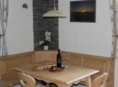 a table with a bottle of wine and wine glasses at Appartamenti Chantal in San Martino in Badia