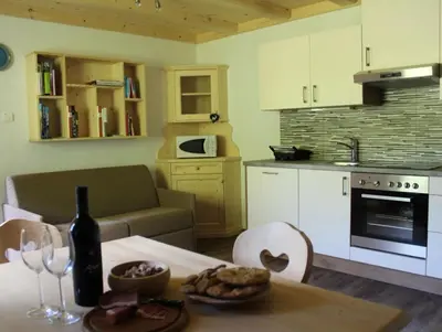 a kitchen with a table with a bottle of wine at Appartamenti Chantal in San Martino in Badia
