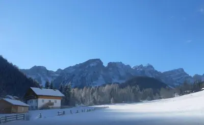 a house in the middle of a snow covered mountain at Appartamenti Chantal in San Martino in Badia
