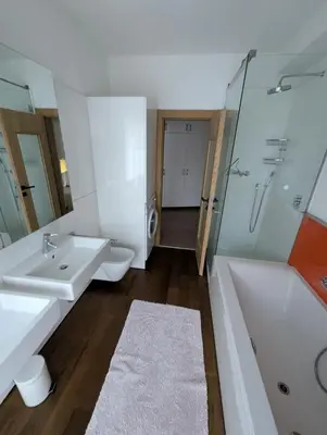 a bathroom with two sinks and a shower and a tub at Oase mit Fernblick in Mühlbach