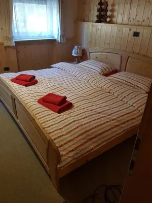 a large bed with two red pillows on it at Casa dolce casa in Vols am Schlern