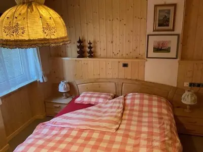 a bedroom with a bed with a checkered blanket at Casa dolce casa in Vols am Schlern