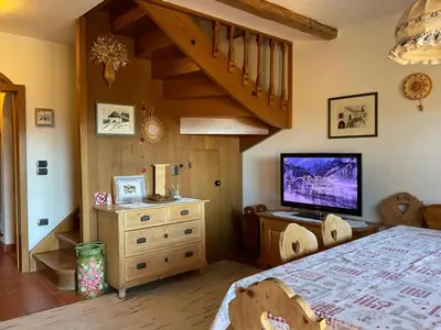 a bedroom with a staircase and a bed with a television at Casa dolce casa in Vols am Schlern