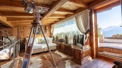 a camera in a room with a bed and a window at Chalet Fenice by My Villa Collection in Cortina dʼAmpezzo