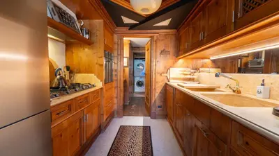 a large kitchen with wooden cabinets and a washing machine at Chalet Fenice by My Villa Collection in Cortina dʼAmpezzo