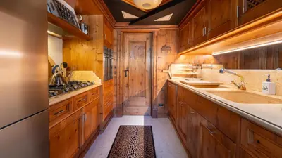 a large kitchen with wooden cabinets and a sink at Chalet Fenice by My Villa Collection in Cortina dʼAmpezzo