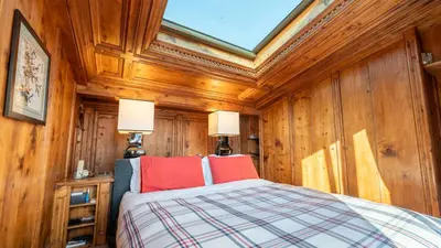 a bedroom with wooden walls and a bed with red pillows at Chalet Fenice by My Villa Collection in Cortina dʼAmpezzo