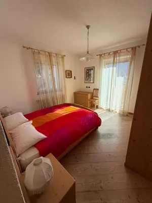 a kitchen with white cabinets and a table and a window at Casa Lilla Predazzo in Predazzo