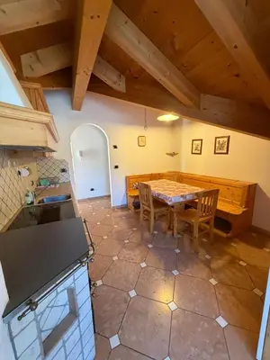 a hallway with a wooden door and a tile floor at Casa Lilla Predazzo in Predazzo