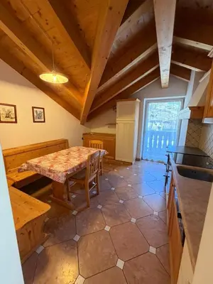 a living room with wooden ceilings and a blue couch at Casa Lilla Predazzo in Predazzo