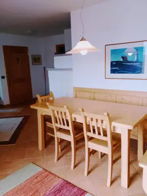 a dining room with a wooden table and chairs at Casa Lilium in Daiano