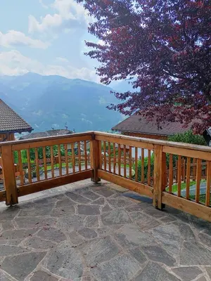 a wooden deck with a view of the mountains at Casa Lilium in Daiano