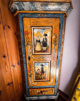 a wooden cabinet with two pictures of people on it at Cortina Wood Home - a short walk from the center in Cortina dʼAmpezzo