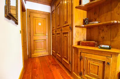 a kitchen with wooden cabinets and a wooden floor at Cortina Wood Home - a short walk from the center in Cortina dʼAmpezzo