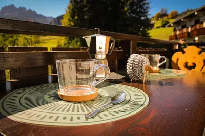 a glass cup sitting on a table with a spoon at Cortina Wood Home - a short walk from the center in Cortina dʼAmpezzo
