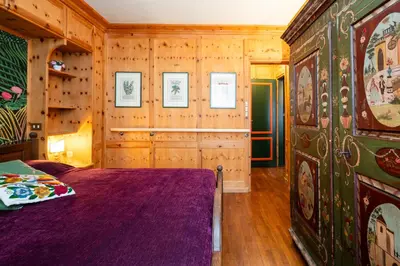 a bedroom with a bed and a wooden wall at Ca dei Castori in Cortina dʼAmpezzo