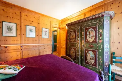 a bedroom with a large bed and wooden walls at Ca dei Castori in Cortina dʼAmpezzo