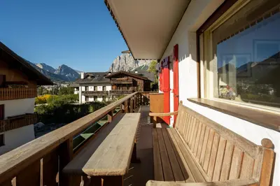 a wooden bench on a balcony with a view of mountains at Ca dei Castori in Cortina dʼAmpezzo