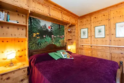 a bedroom with a bed in a wooden room at Ca dei Castori in Cortina dʼAmpezzo