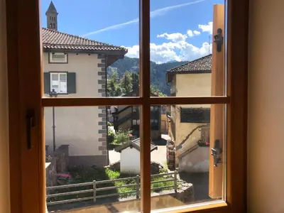 an open window with a view of a city at Ca' Stella in Castello di Fiemme