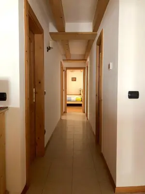 a corridor of a room with wooden ceilings at Ca' Stella in Castello di Fiemme
