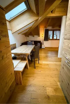 a dining room with a wooden table and chairs at Pragma Apartments - Wood Lodge Predazzo in Predazzo